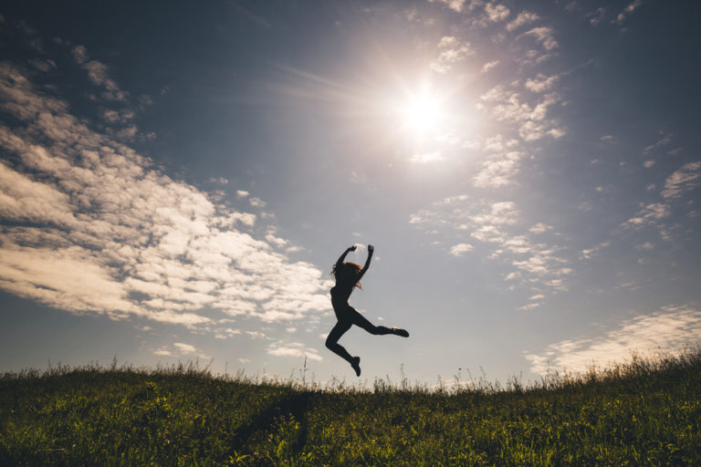 mujer silueta saltando en el campo feliz
