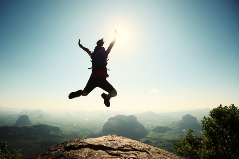 silueta de mujer saltando en el monte en la montaña feliz disfrutando superación motivación